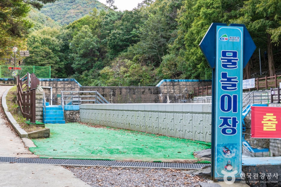 물놀이장 출입 표지와 낮은 수경시설 수조, 주변 울타리와 계단