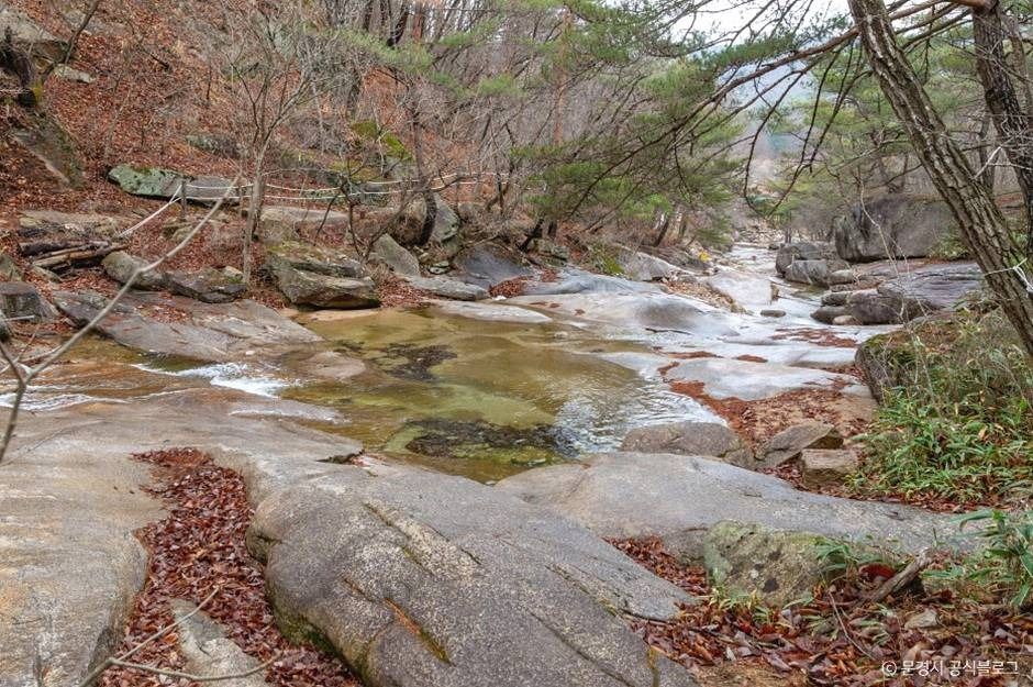숲 사이 넓은 암반을 따라 물길이 이어지는 대야산 용추계곡