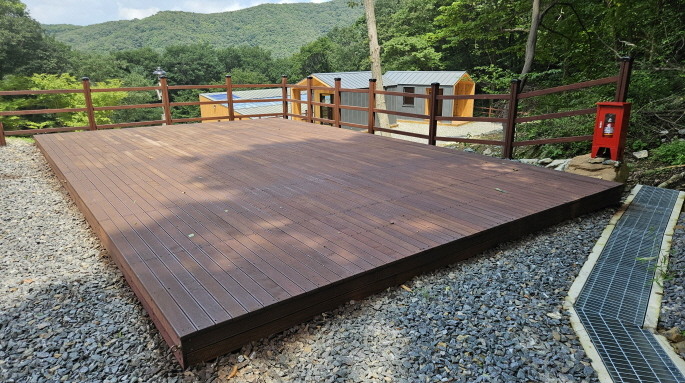 국립회문산자연휴양림 산비탈의 넓은 직사각형 야영데크 101과 난간·배전함·아래쪽 캐빈
