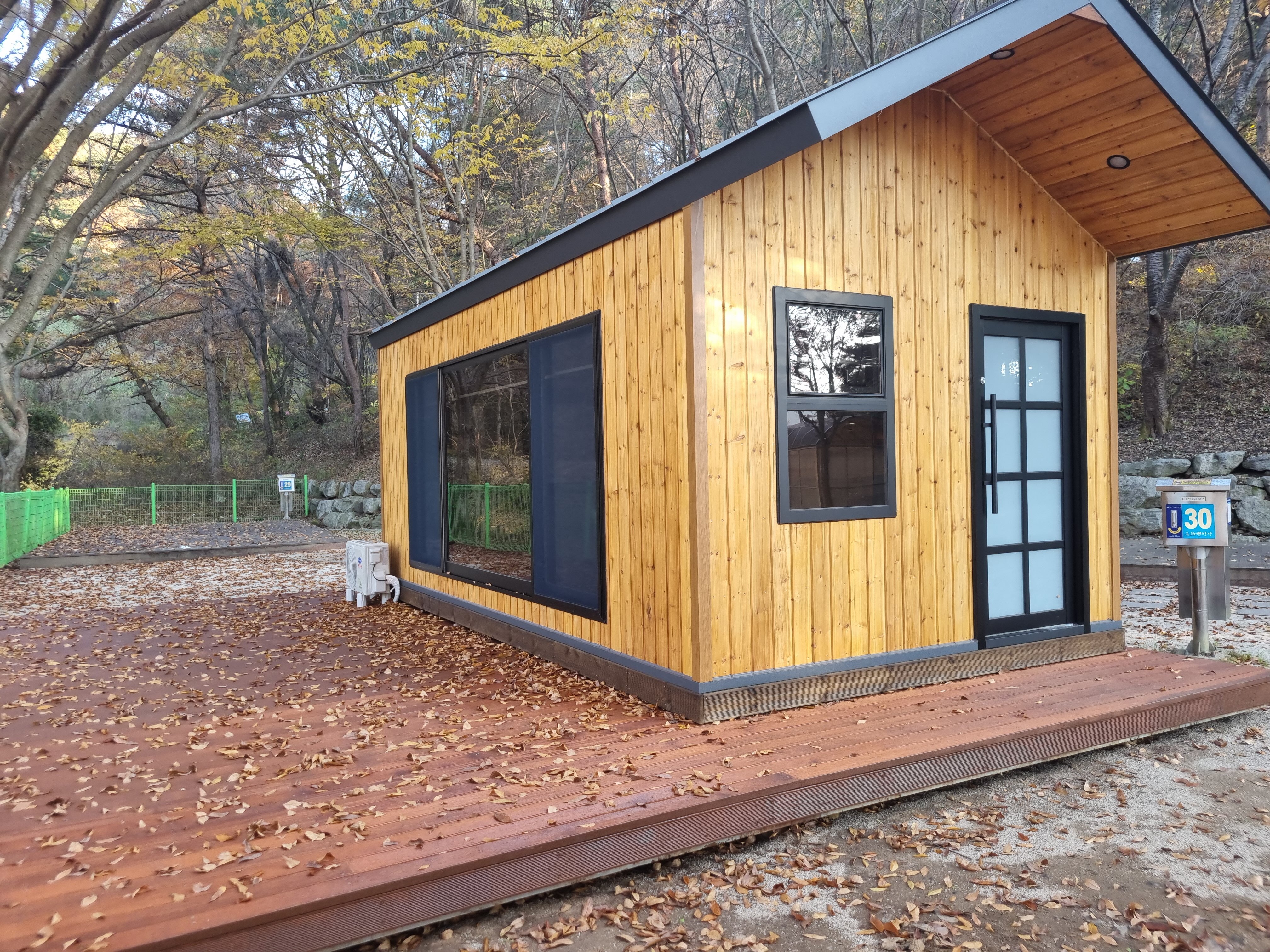 30번 표지 옆 목재 외벽 캠핑하우스와 외부 데크