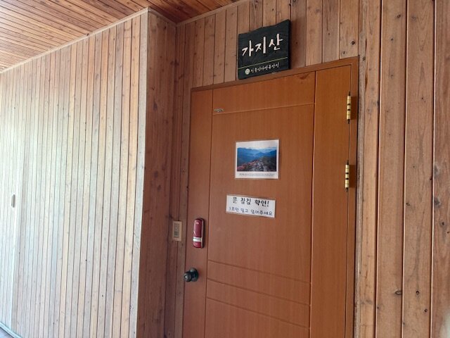목재 벽과 가지산 표찰이 보이는 캐빈 출입문