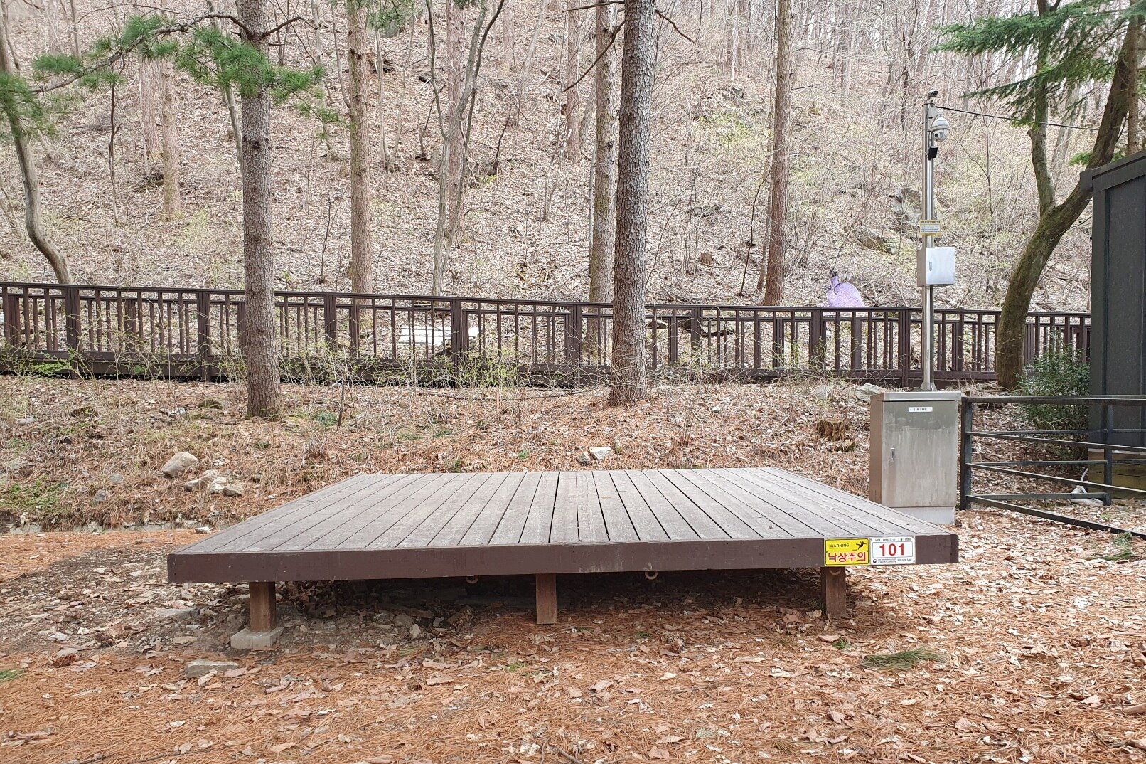 국립유명산자연휴양림 나무 사이에 놓인 목재 야영데크와 주변 흙바닥