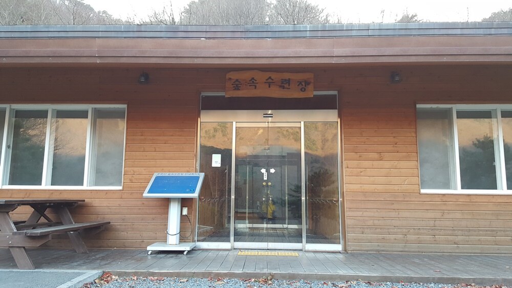 숲속수련장의 유리 출입문과 목재 외벽